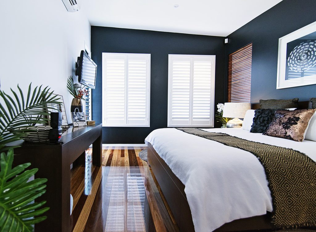 white timber shutters against dark wall in master bedroom